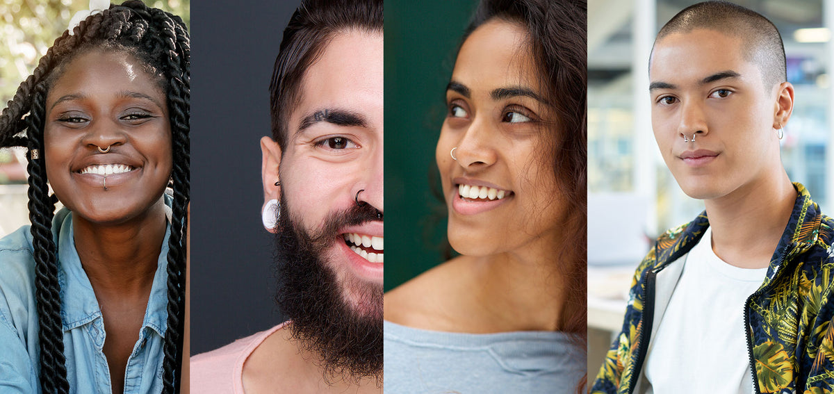 Four smiling people: two with septum rings, one with a nostril hoop, and a bearded man with a nostril hoop and white plug